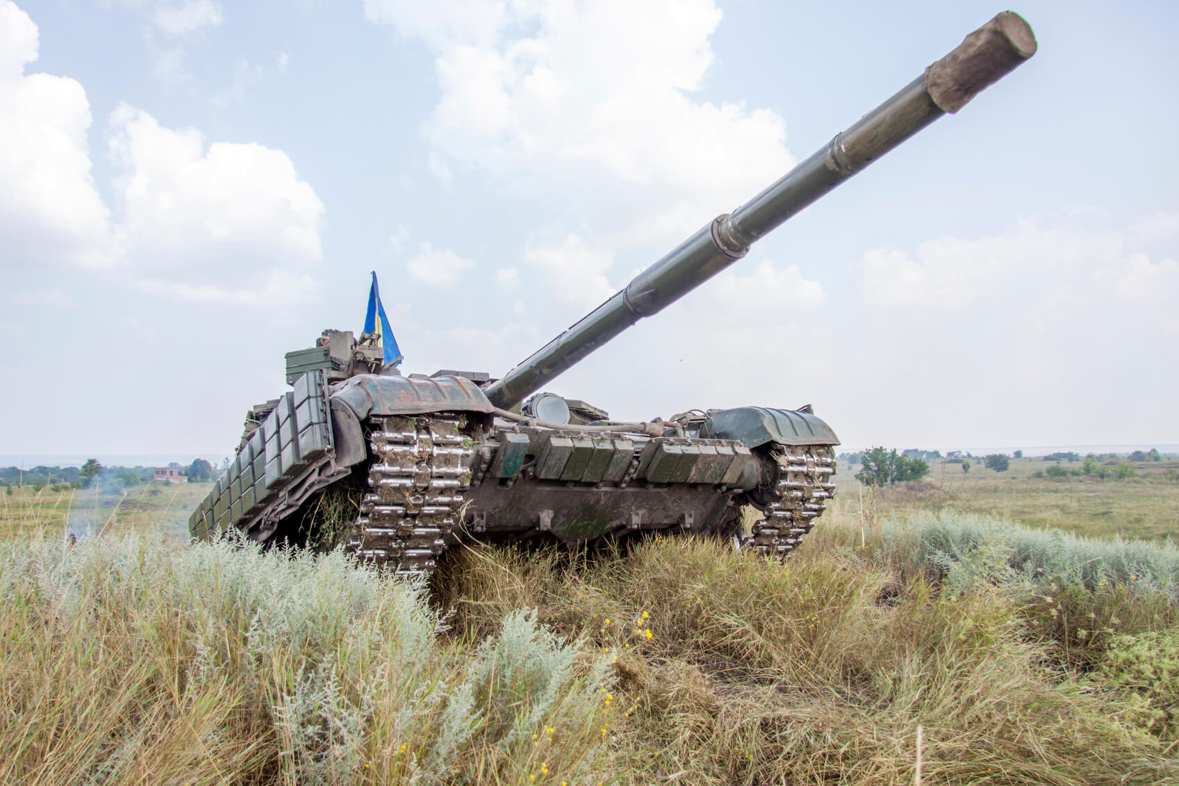 green armoured tank in an empty grass field