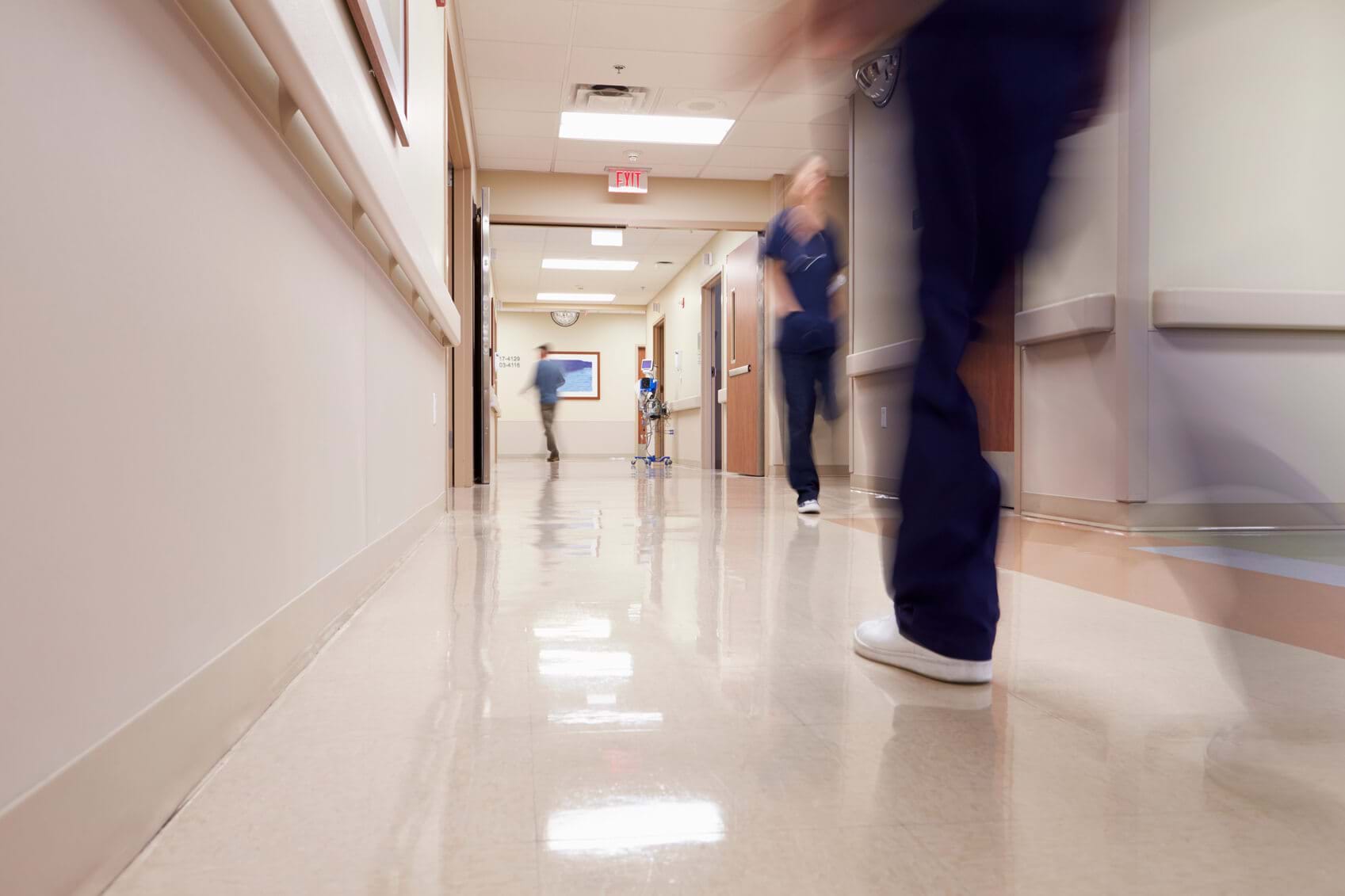 blurred image of medical staff moving along a hospital corridor