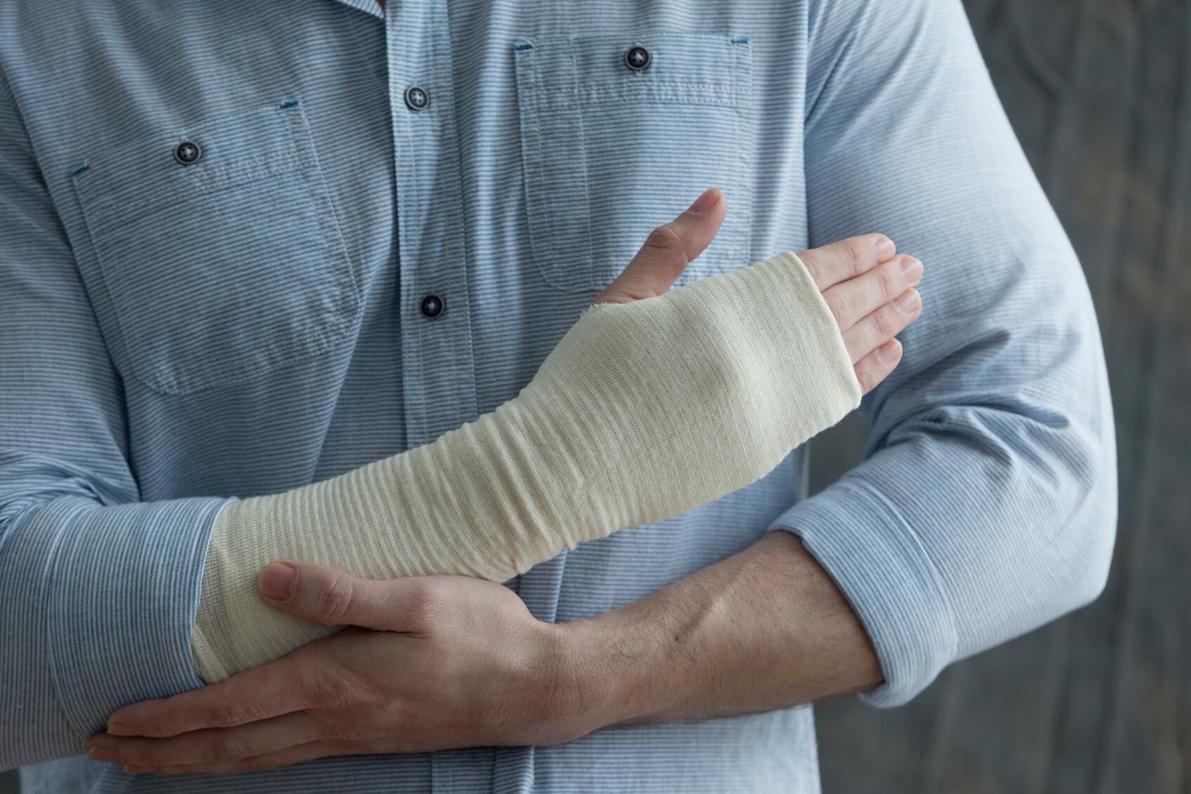 A man holds his bandaged wrist