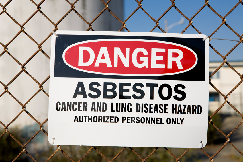 rusted chain link fence with asbestos warning sign