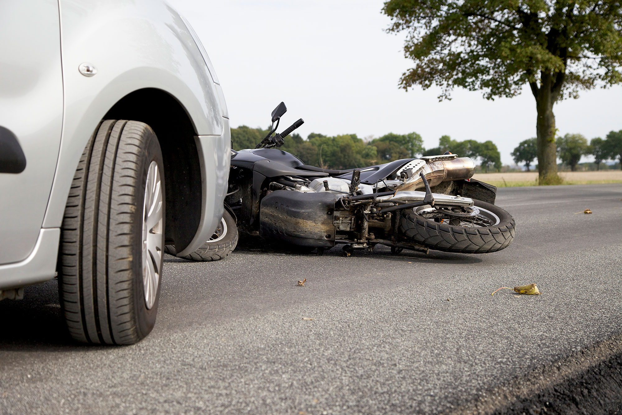 Motorcycle in front of a silver car.