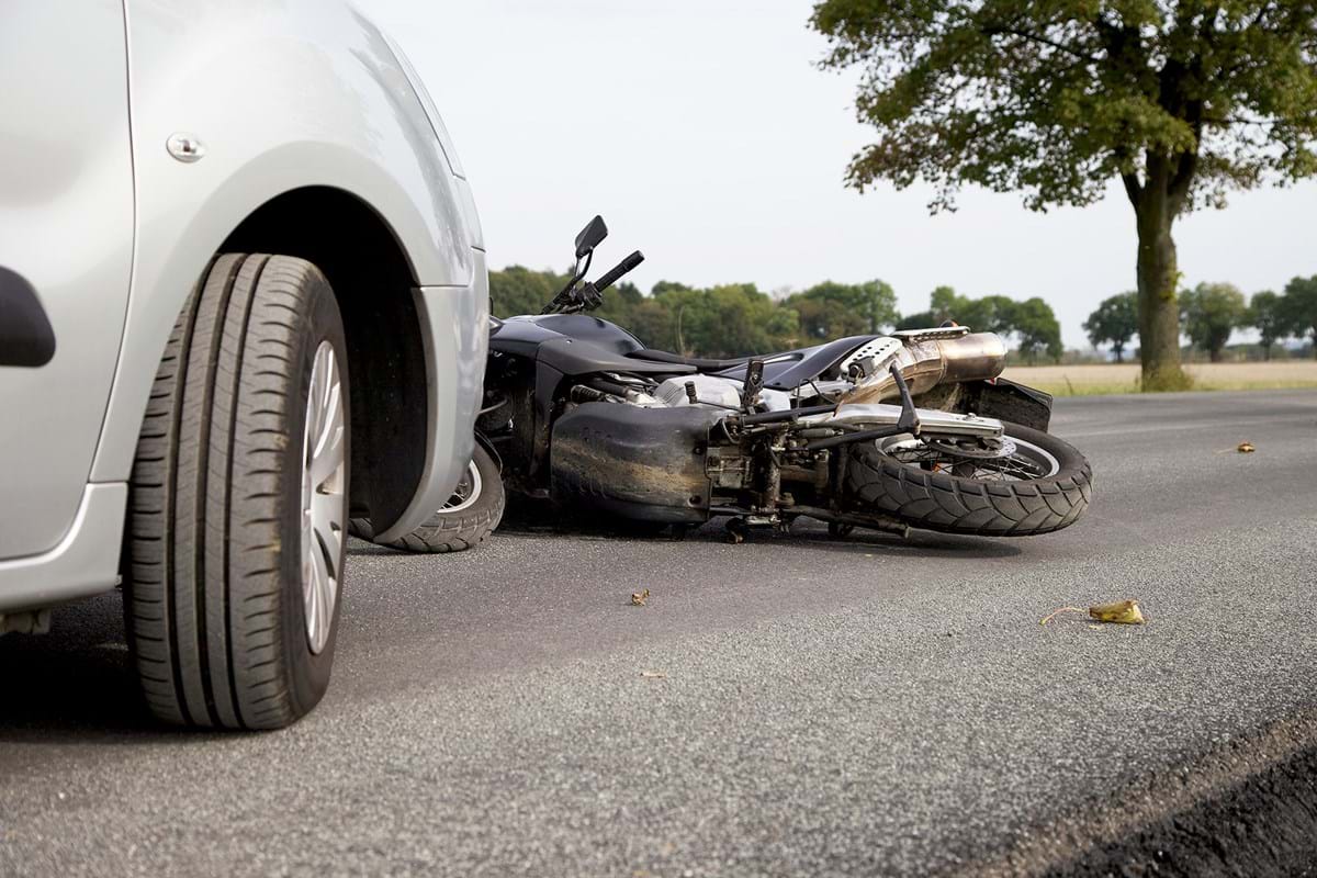 Motorcycle in front of a silver car.