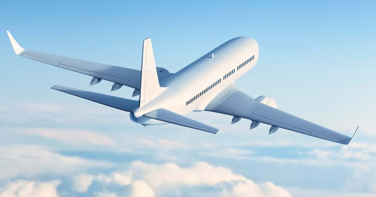 airplane flying over white clouds in a blue sky