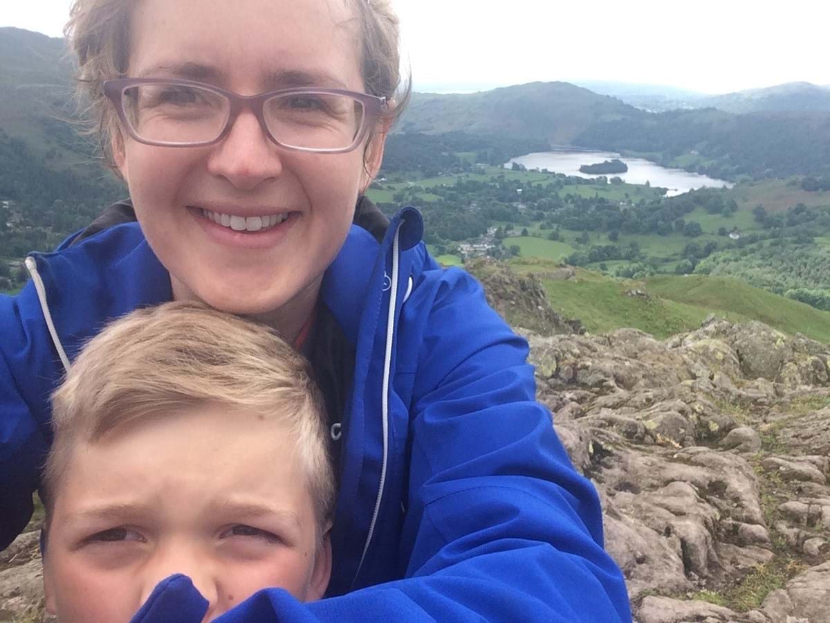 Helen Shakespeare wearing a blue coat, with her son