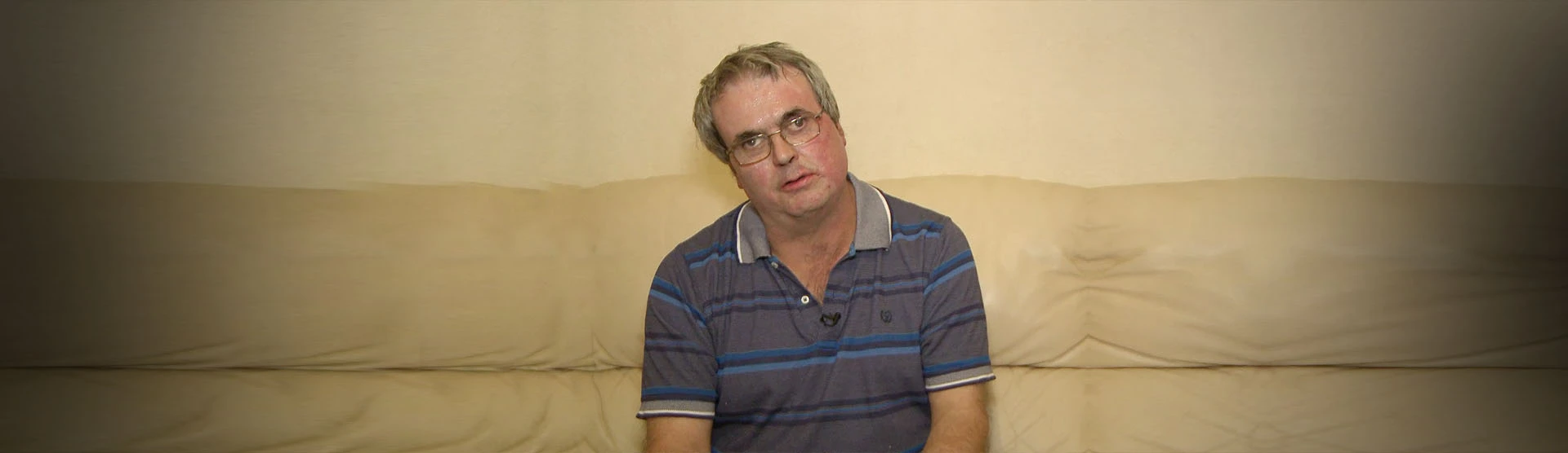 Our serious burns injury client, David, sat on his sofa.