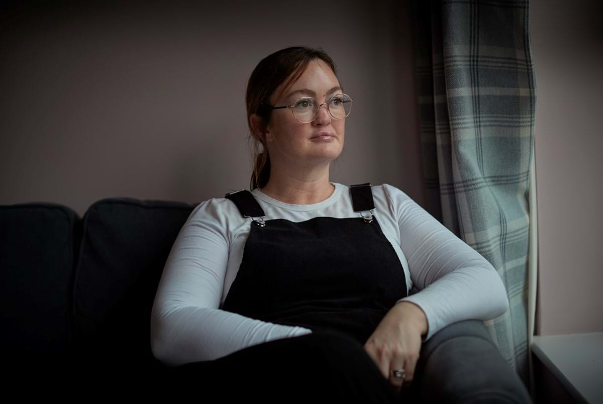 Woman sitting on a couch looking out the window