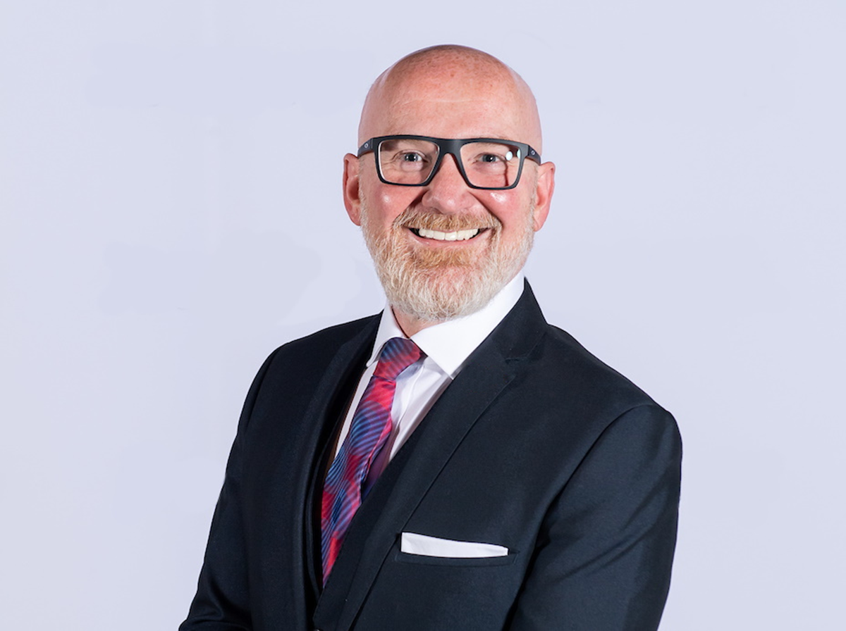 A man wearing glasses and smiling