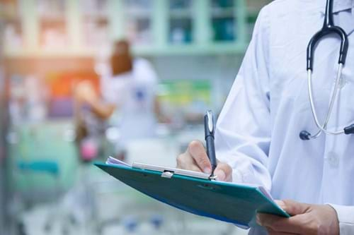 Doctor writing notes on a clipboard