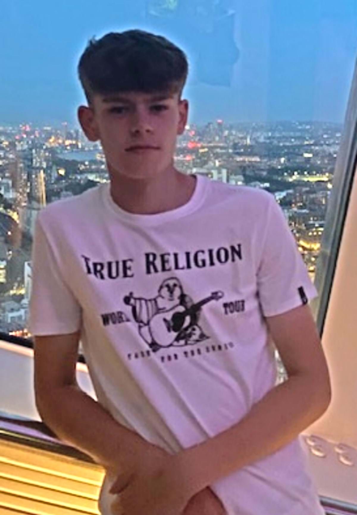 A young boy wearing a white top